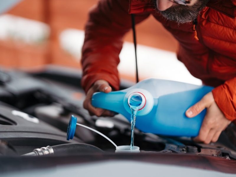 Pouring,Winter,Washer,Fluid,Into,Car,Reservoir,During,Winter,,Protecting